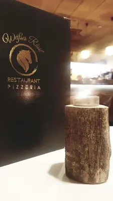 a book sitting next to a tree stump at Weißes Rössl in Appiano sulla Strada del Vino
