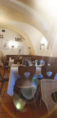 a restaurant with tables and chairs in a room at Weißes Rössl in Appiano sulla Strada del Vino