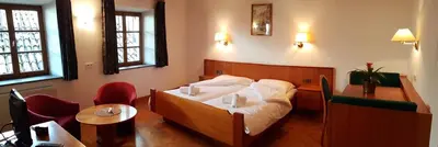 a hotel room with a bed and a table and chairs at Weißes Rössl in Appiano sulla Strada del Vino