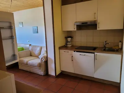 a kitchen with a couch and a chair in a room at Appartements Pension Sonia in Funes