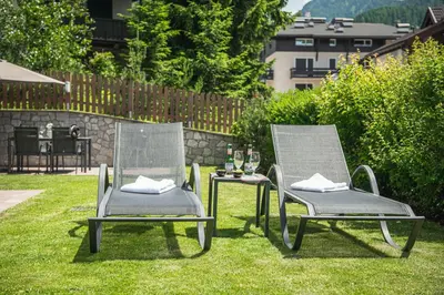 two chairs and a table in the grass at AMONIT - CLAUDIA in Selva di Val Gardena