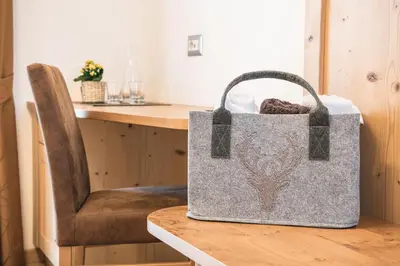 a bag sitting on a table next to a chair at AMONIT - CLAUDIA in Selva di Val Gardena