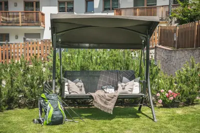 a gazebo with a chair and pillows in a yard at AMONIT - CLAUDIA in Selva di Val Gardena