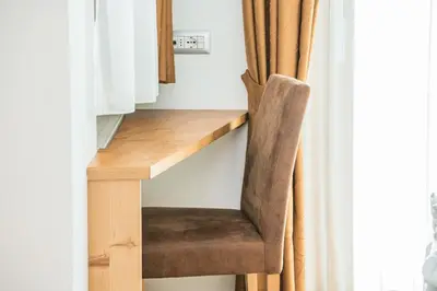 a chair sitting next to a desk next to a window at AMONIT - CLAUDIA in Selva di Val Gardena