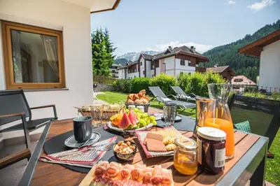 a table with food and drinks on a balcony at AMONIT - CLAUDIA in Selva di Val Gardena