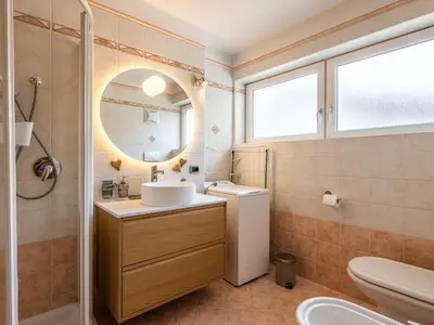 a bathroom with a shower and a wooden door at Apartment Cesa Soraruf by Interhome in Campitello di Fassa