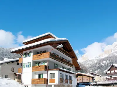 a building with cars parked in a parking lot at Apartment Cesa Soraruf by Interhome in Campitello di Fassa
