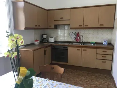 a kitchen with wooden cabinets and a stove top oven at Appartamento Nadia in Merano