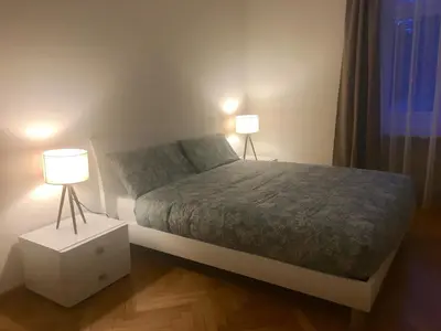 a bedroom with a bed with two lamps on it at Appartamento Nadia in Merano