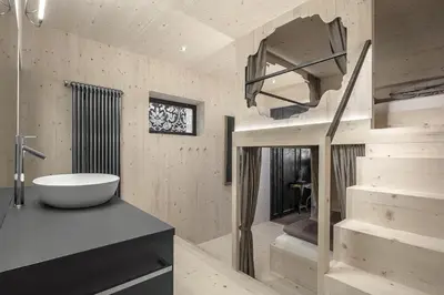 a bathroom with a tub and a sink and a staircase at Artefugium Atelier in Selva di Val Gardena