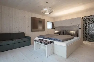 a bedroom with a large bed and a couch at Artefugium Atelier in Selva di Val Gardena