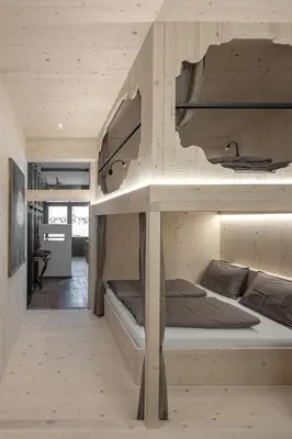 two bunk beds in a room with a kitchen at Artefugium Atelier in Selva di Val Gardena