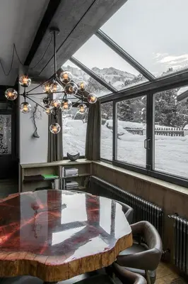 a dining room with a table and a large window at Artefugium Atelier in Selva di Val Gardena