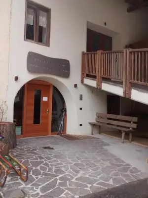a building with a wooden door and a bench at Agriroom in Rumo