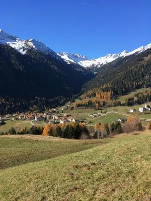 a small town in a valley with snow covered mountains at Agriroom in Rumo