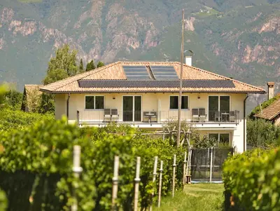 a large white house with a fence in front of it at Weingut am Platzl in Appiano sulla Strada del Vino