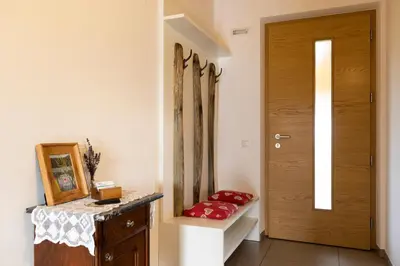 a hallway with a wooden door and a table at Weingut am Platzl in Appiano sulla Strada del Vino