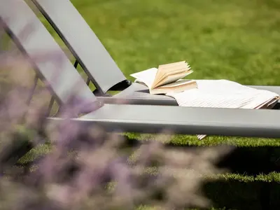 a book sitting on top of a bench in the grass at Weingut am Platzl in Appiano sulla Strada del Vino