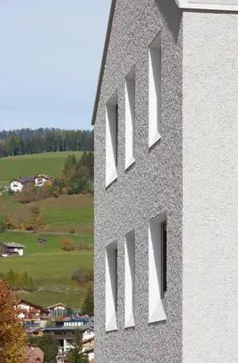 a white building with windows on the side of it at Living Nature Appartements in San Vigilio Di Marebbe