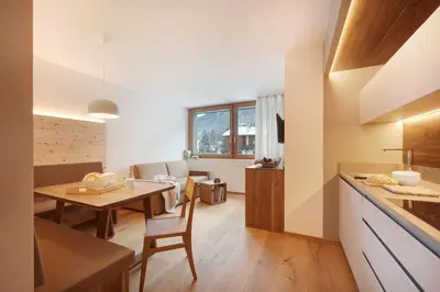 a kitchen and living room with a table and a dining room at Living Nature Appartements in San Vigilio Di Marebbe