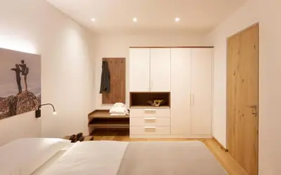 a bedroom with a bed and a cabinet at Living Nature Appartements in San Vigilio Di Marebbe