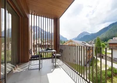 a balcony with a table and chairs and mountains at Living Nature Appartements in San Vigilio Di Marebbe