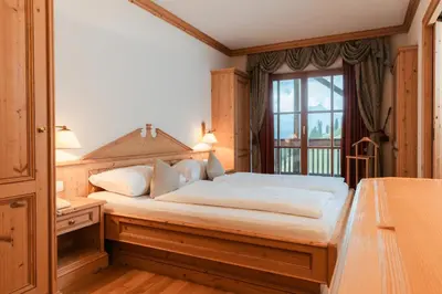 a bedroom with a bed and a window at Lüch Da Pćëi in San Cassiano