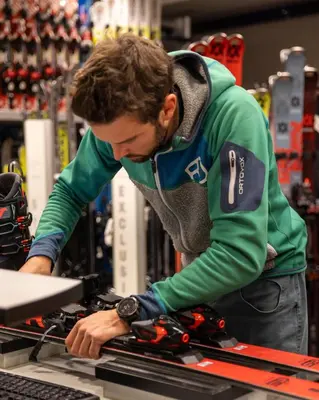 a man working on a computer in a store at Lüch Da Pćëi in San Cassiano