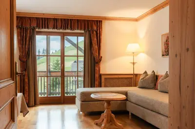 a living room with a couch and a large window at Lüch Da Pćëi in San Cassiano