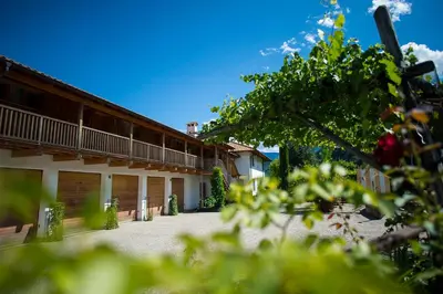 a building with a balcony and a tree at St. Ulrichhof in Lana