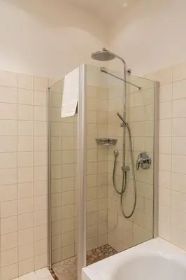 a bathroom with a shower with a tub at St. Ulrichhof in Lana