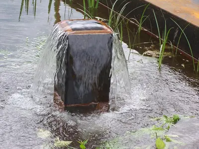 a water fountain in the middle of a body of water at St. Ulrichhof in Lana