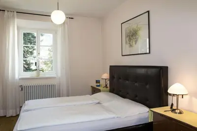 a bedroom with a bed with a black headboard and a window at Villa Lageder in Sarntal
