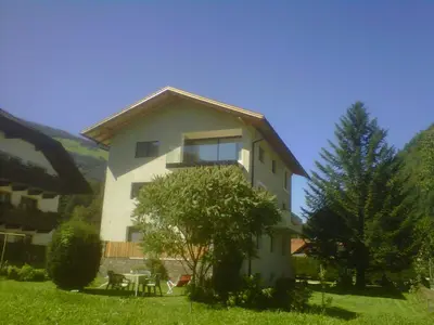 a building with a table and a tree in front of it at MANTANA - Apartments in San Lorenzo di Sebato