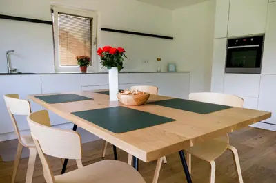 a kitchen with a wooden table and chairs at MANTANA - Apartments in San Lorenzo di Sebato