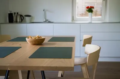 a wooden table with chairs and a bowl of food on it at MANTANA - Apartments in San Lorenzo di Sebato