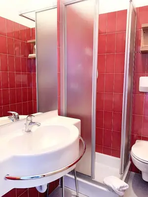 a aisle of a bathroom with towels on shelves at Hotel Latemar in Castello di Fiemme
