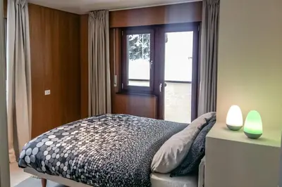 a bedroom with a bed next to a window at Residence Des Alpes in Canazei