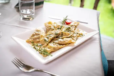 a white plate of food on a table at Gasthof Rabenstein in Sarntal