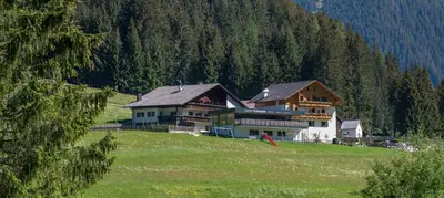 a large house on a hill in a field at Gasthof Rabenstein in Sarntal