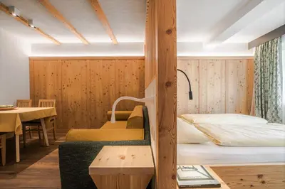 a hotel room with a bed and a table at Appartamenti Residence Ada in San Cassiano