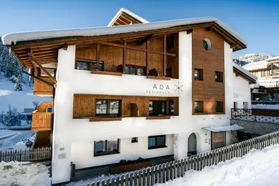 a home in the winter with snow on the ground at Appartamenti Residence Ada in San Cassiano