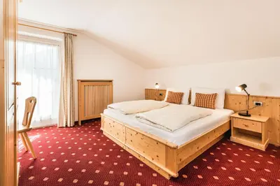 a bedroom with a large bed and a red carpet at Villa Scherlin in Ortisei