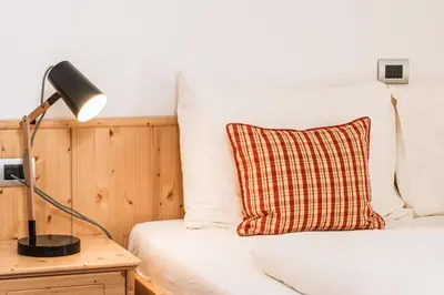 a bedroom with a bed with a lamp and a pillow at Villa Scherlin in Ortisei