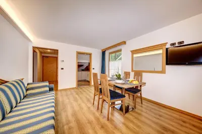 a living room with a couch and a table at Aparthotel Wellness Villa di Bosco in Tesero