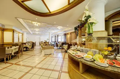 a restaurant with a buffet line with food on it at Aparthotel Wellness Villa di Bosco in Tesero