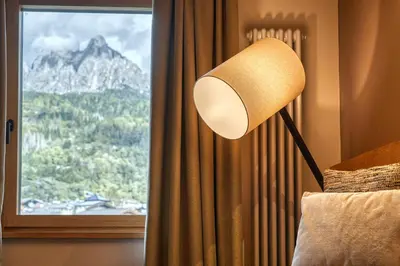 a lamp in a room with a view of a mountain at Brunet - The Dolomites Resort in Fiera di Primiero