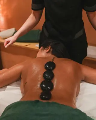 a man laying on a bed with beads on his back at Brunet - The Dolomites Resort in Fiera di Primiero