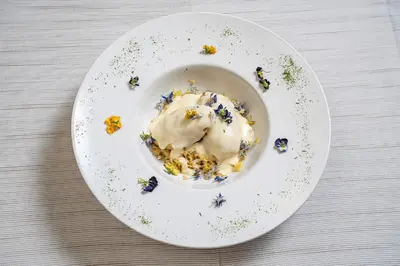 a white plate with a dessert on a table at Brunet - The Dolomites Resort in Fiera di Primiero