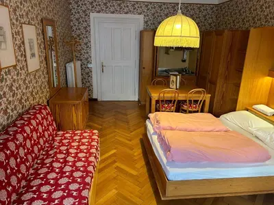 a bedroom with two beds and a table with a mirror at Residence Grand Hotel Carezza in Nova Levante